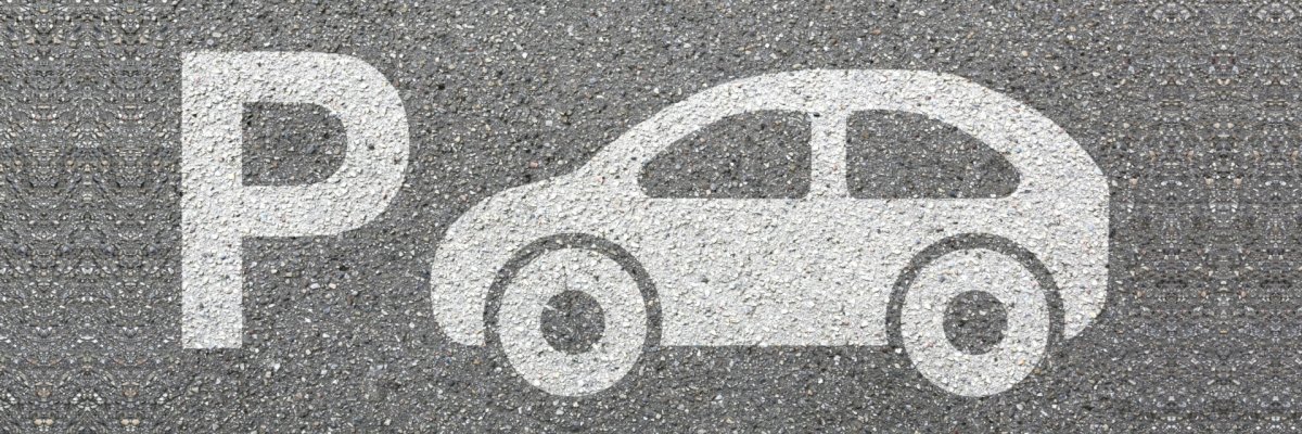 The photo shows a car spray-painted on asphalt and a P as a symbol for parking.