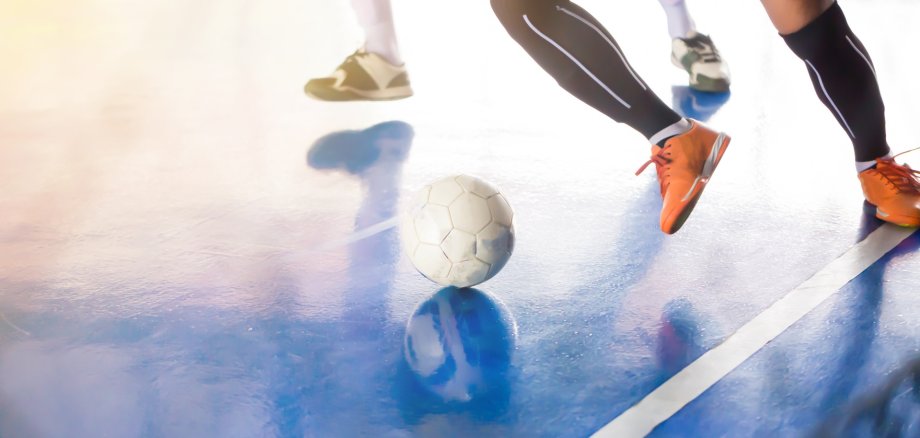 Symbol photo indoor soccer The photo shows the legs of soccer players playing in a sports hall.