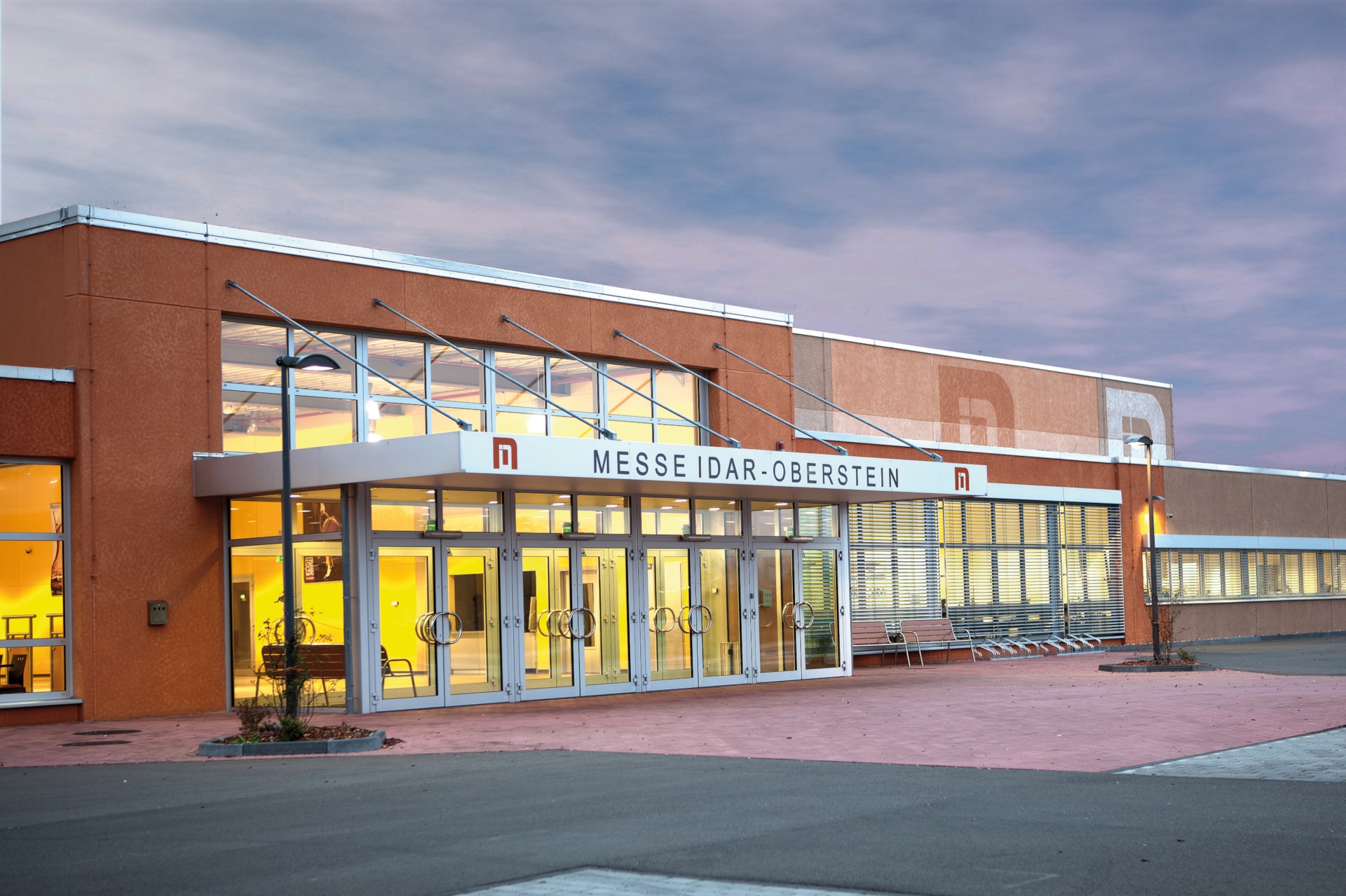 The photo shows an exterior view of the Idar-Oberstein trade fair center.