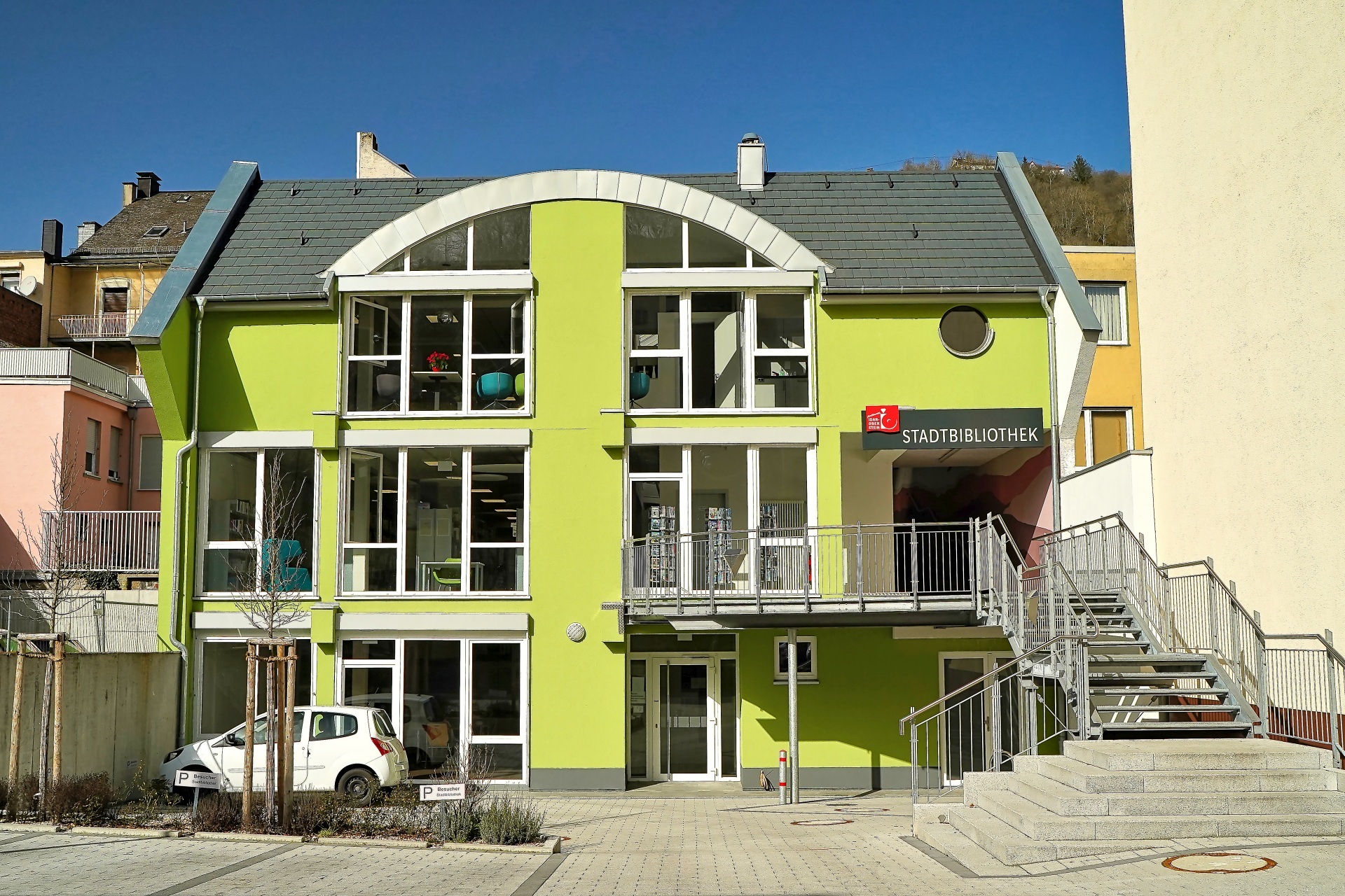 The photo shows the exterior view of the Idar-Oberstein City Library from Austraße.