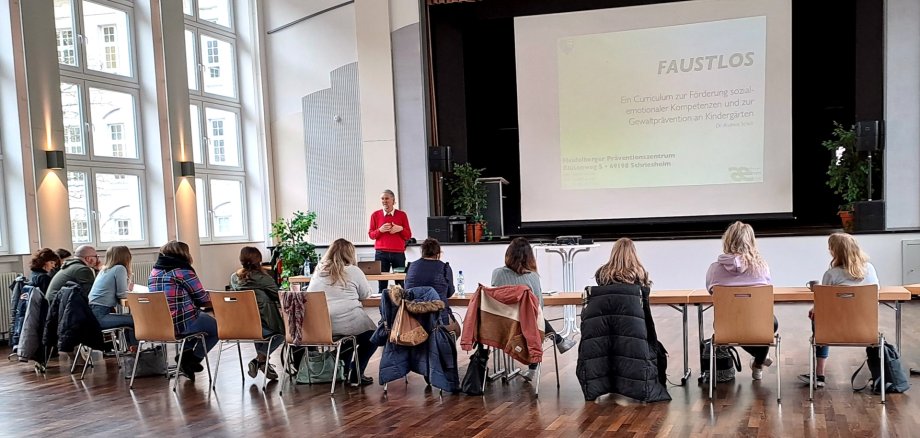 The photo shows the participants of the training course in a row of chairs in front of the lecturer.