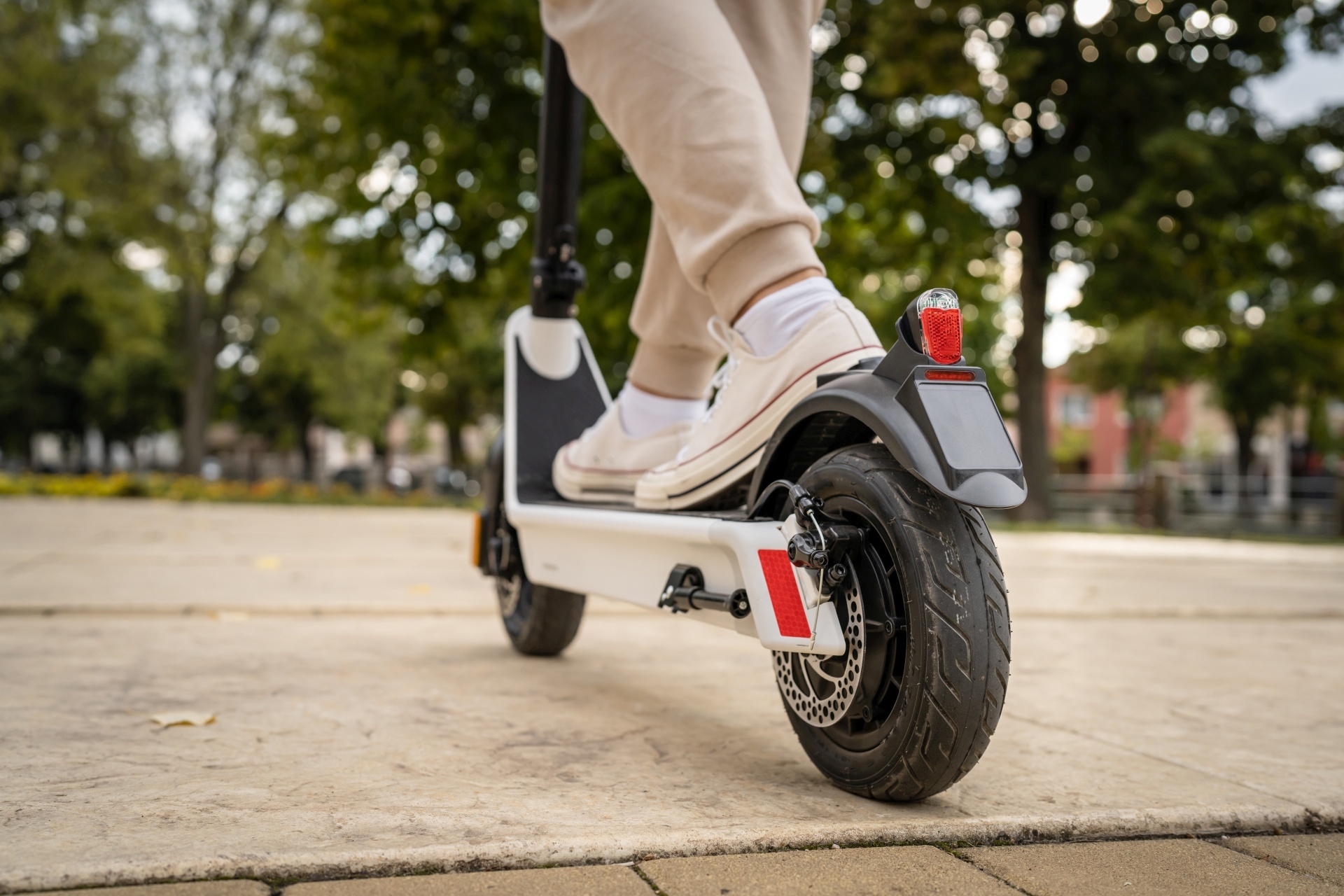The photo shows the feet of a person standing on an e-scooter.