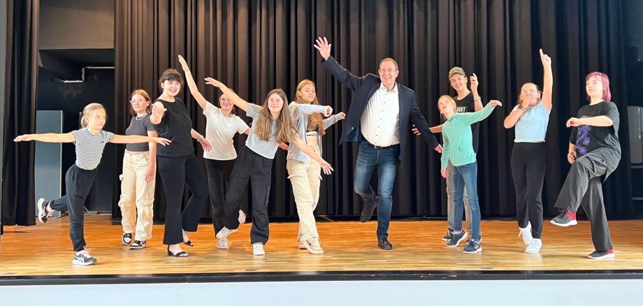 The photo shows the participants together with Lord Mayor Frühauf on the stage of the Göttenbach auditorium. They portray various figures.