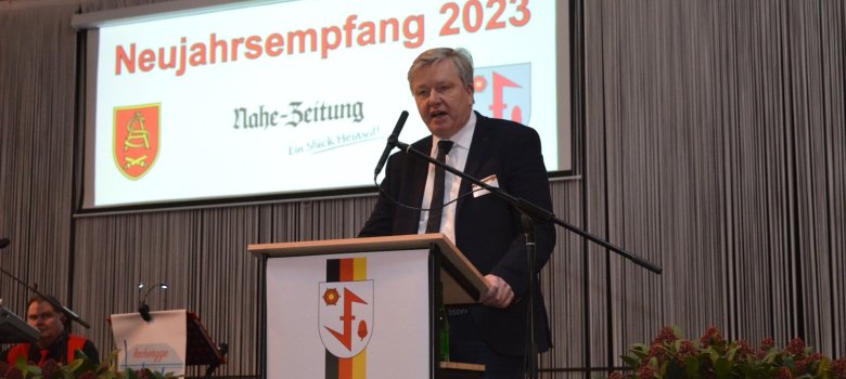 The photo shows Lars Hennemann standing on the stage at the lectern.