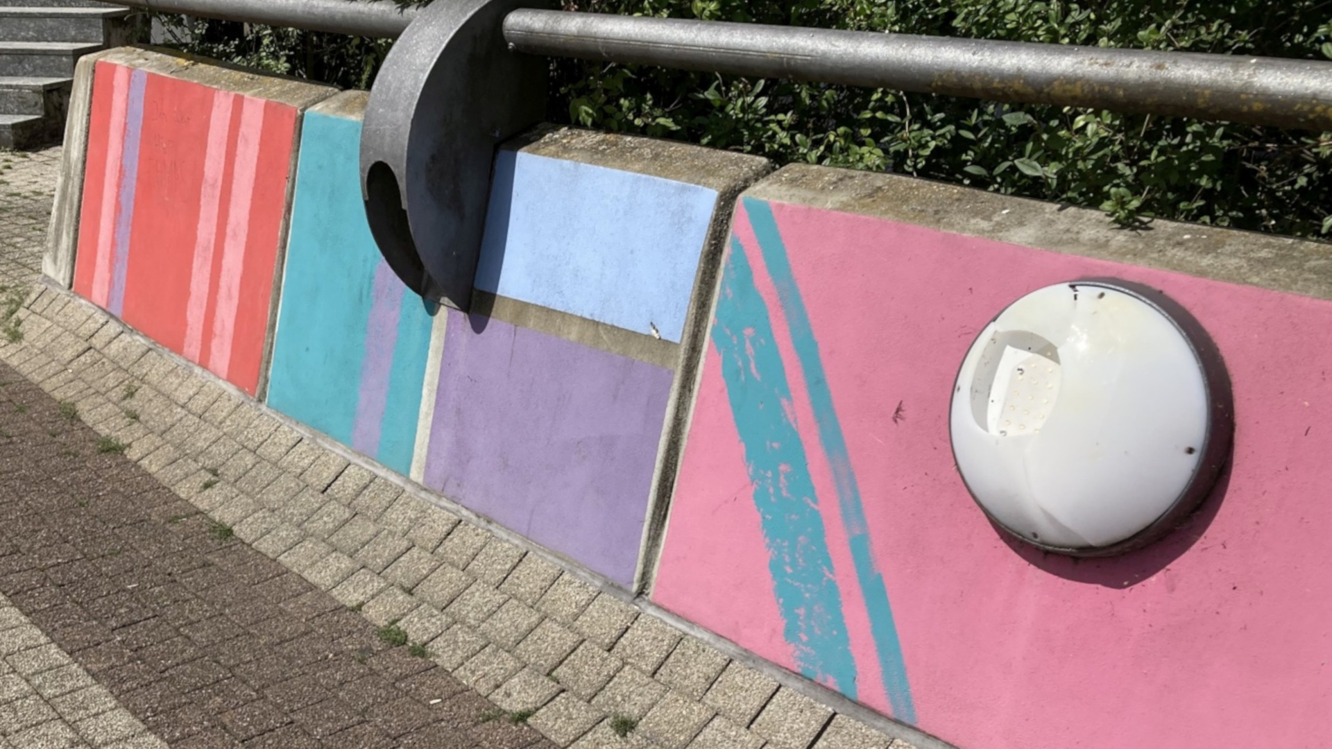 The photo shows a damaged luminaire on a footpath.