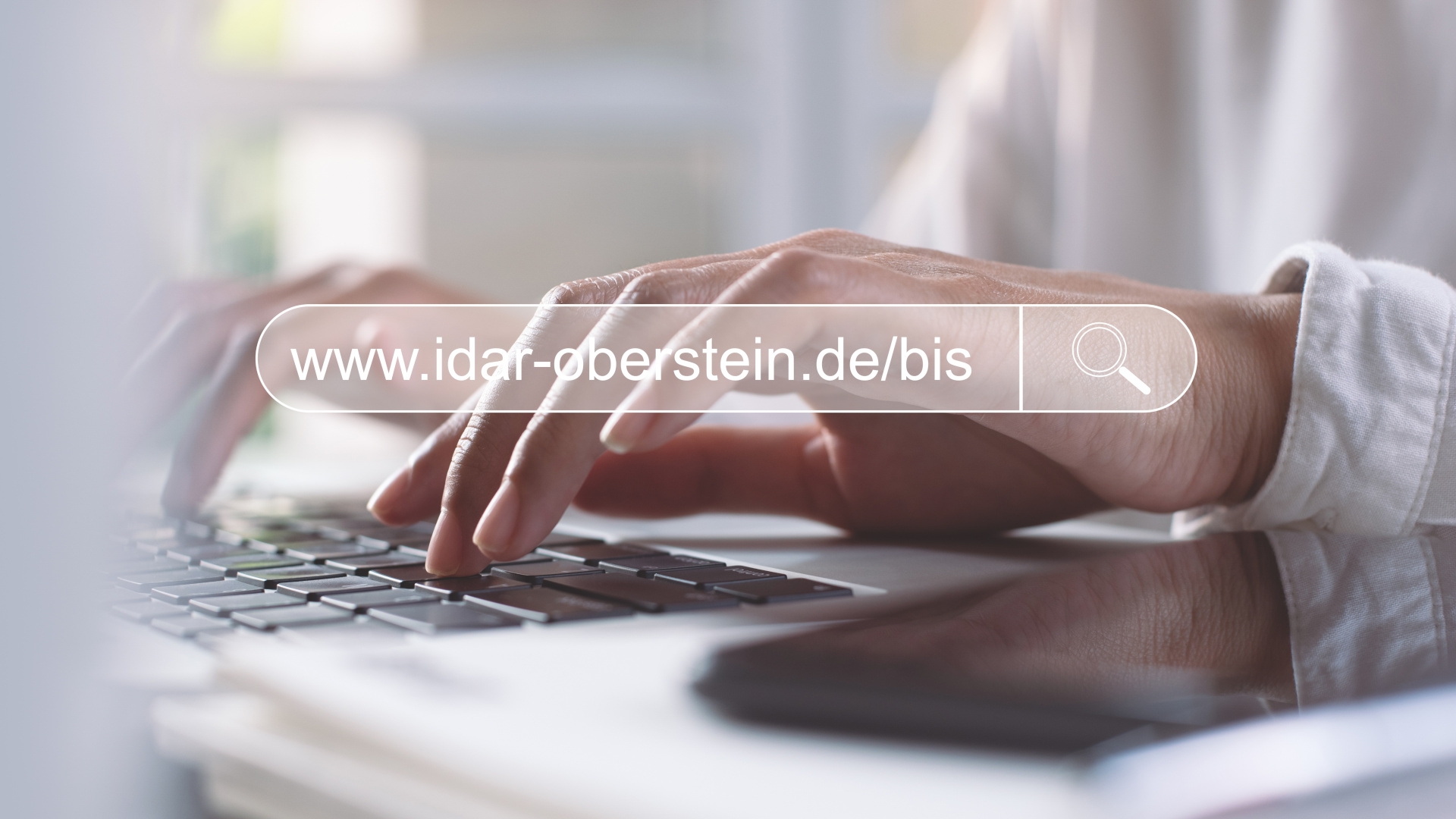 The photo shows hands typing something on a computer keyboard. Above it is the Internet address www.idar-oberstein.de/bis