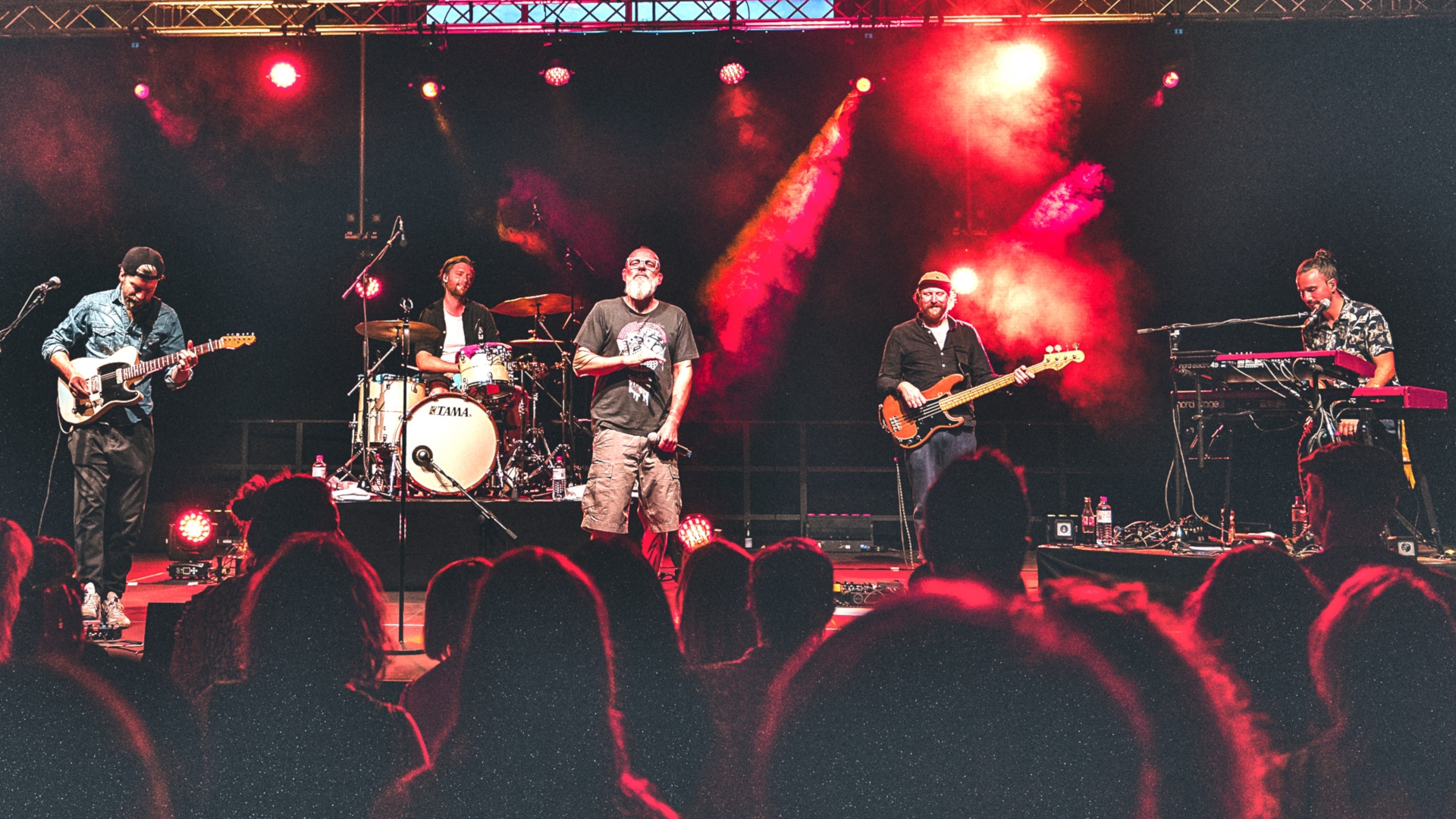 The photo shows the musicians on stage during the concert, with the heads of the audience in the foreground.