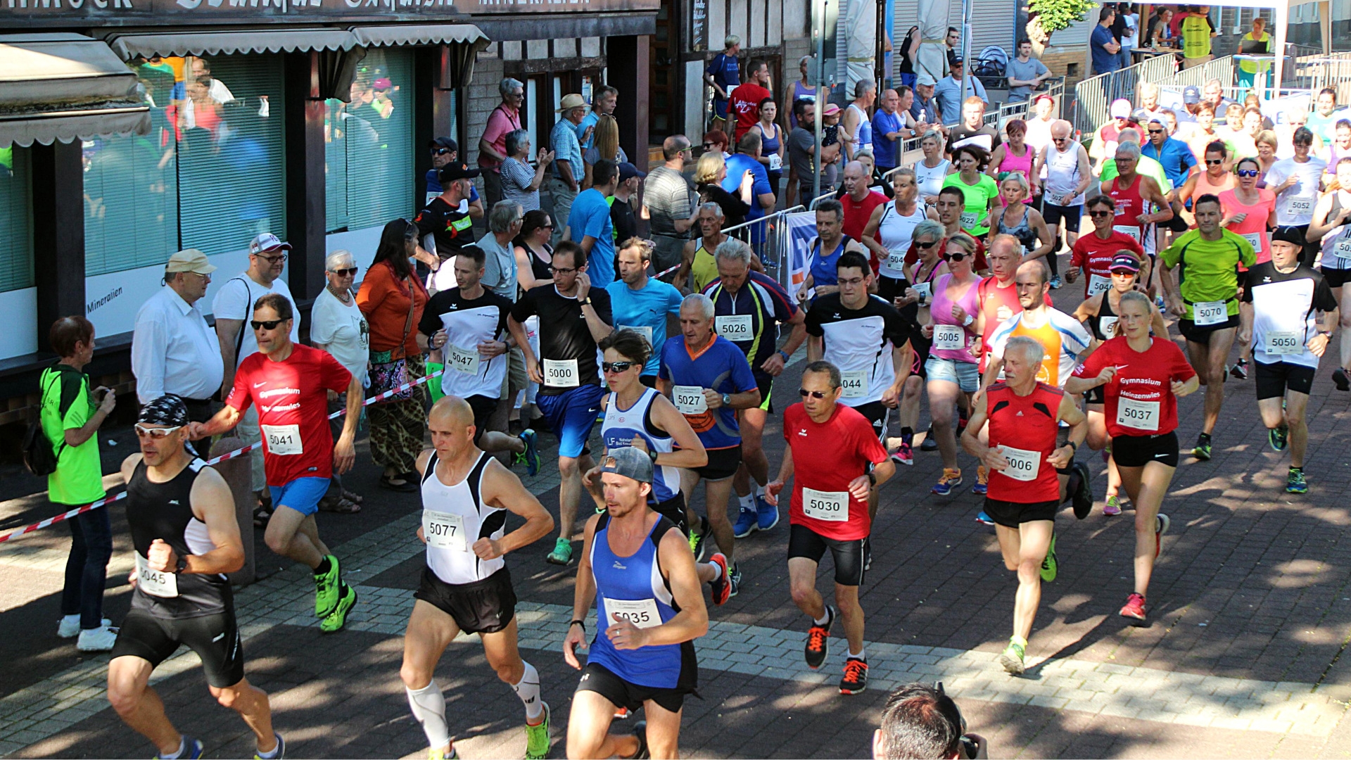 The photo shows a large group of runners on their way through the old town of Oberstein. The route is lined with spectators.