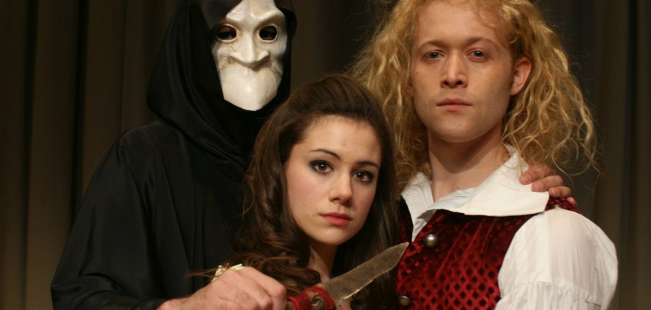 The photo shows the lovers Romeo and Juliet, with Death holding a knife to their throats.