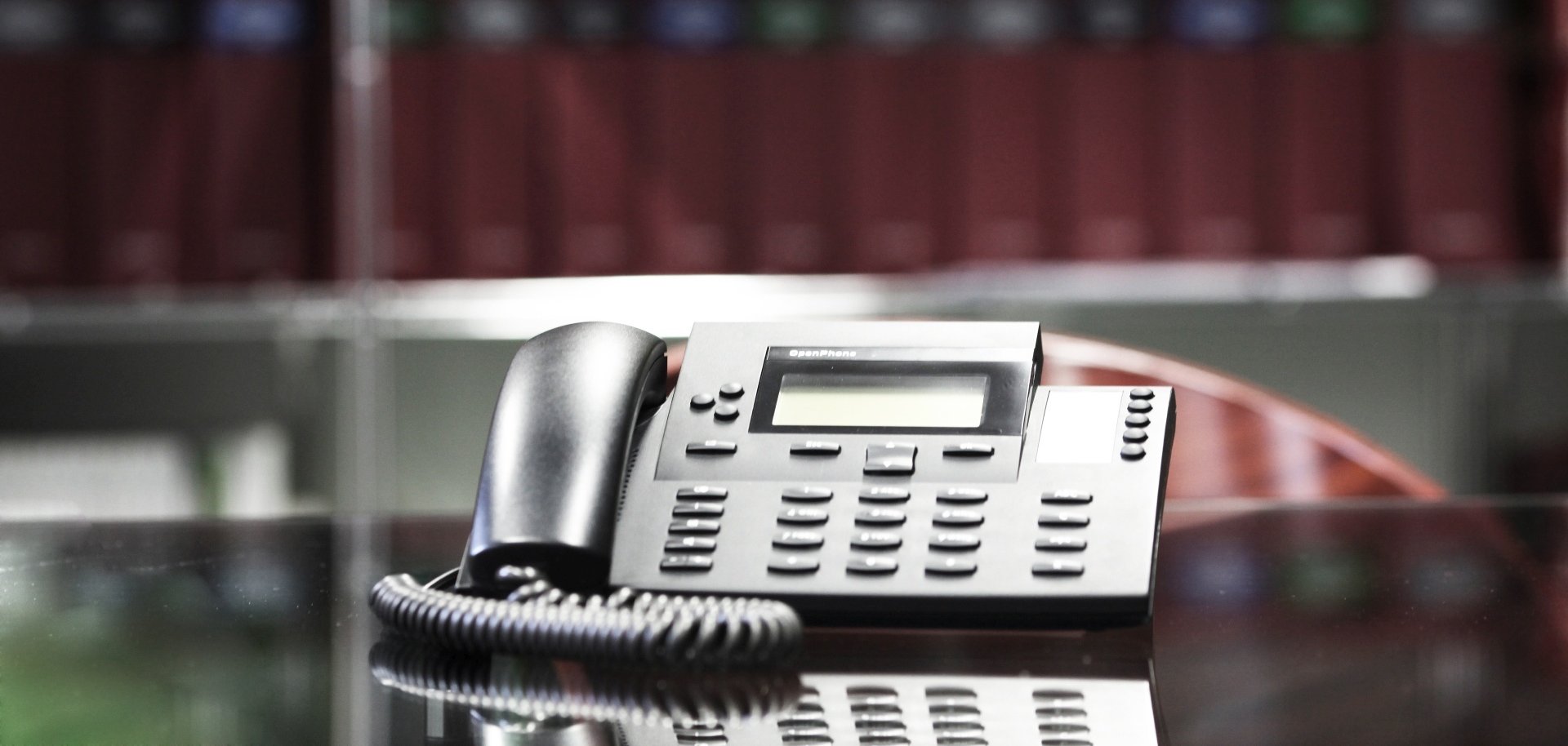 The photo shows a telephone in front of a shelf with files.