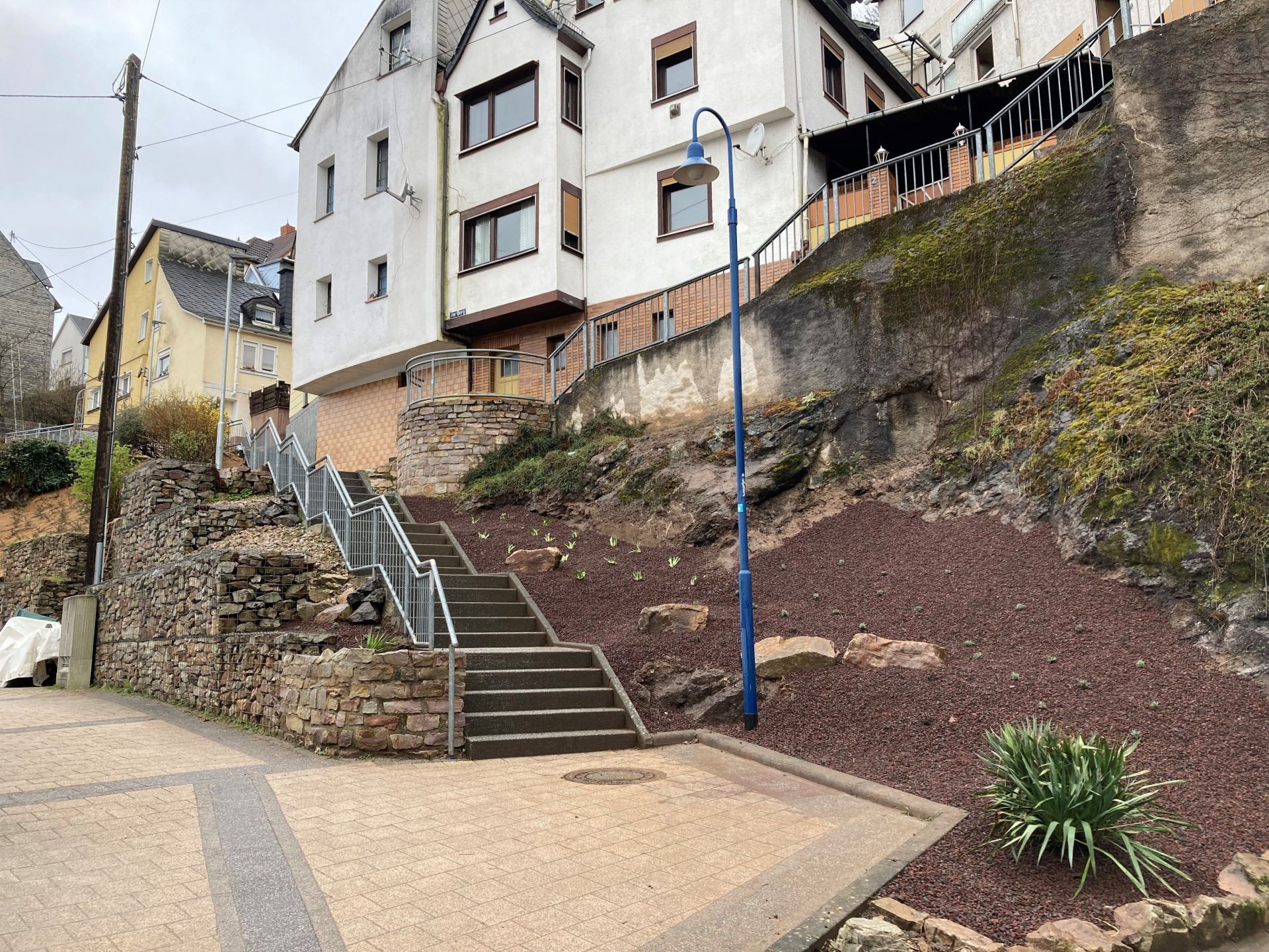 The picture shows a slope on which perennials have been freshly planted between mineral mulch.