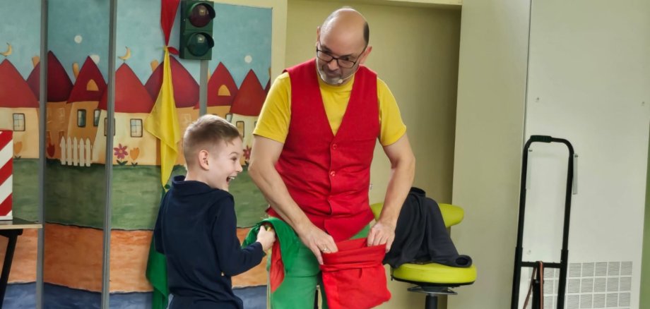 The photo shows the traffic magician Robert performing a trick with a child.