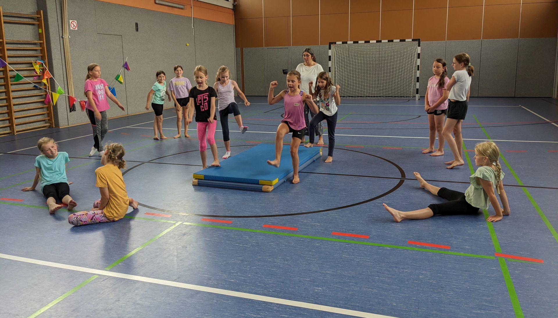 The photo shows the girls and the trainer in a sports hall.