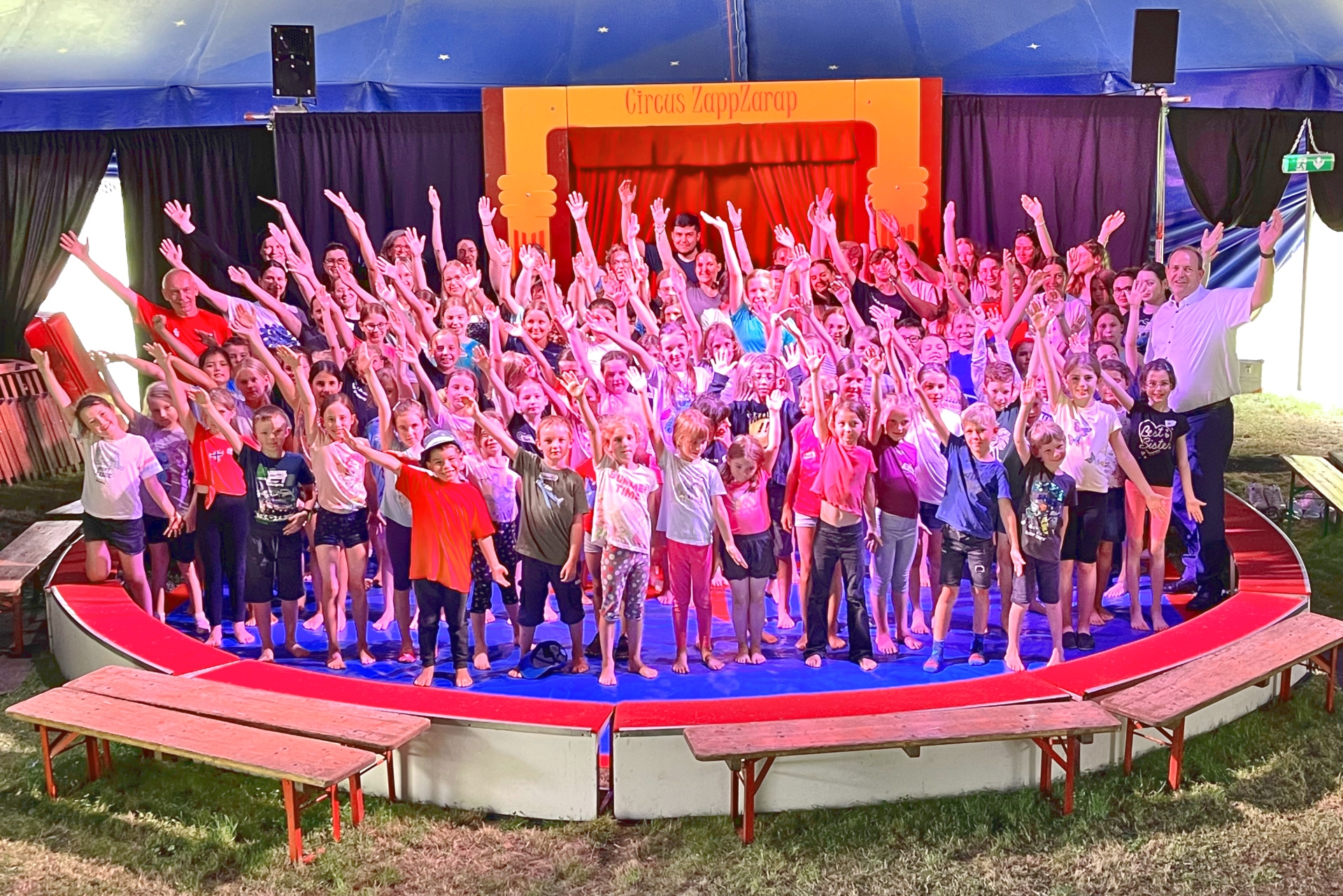 The photo shows the children with their supervisors, the Lord Mayor and the representative of the Kreissparkasse. They are all standing in the ring, looking at the camera and have their right arm stretched upwards and their left arm downwards.