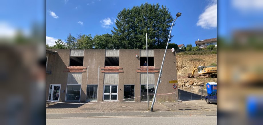 The photo shows the lamppost standing in front of a building. It is leaning due to the accident.
