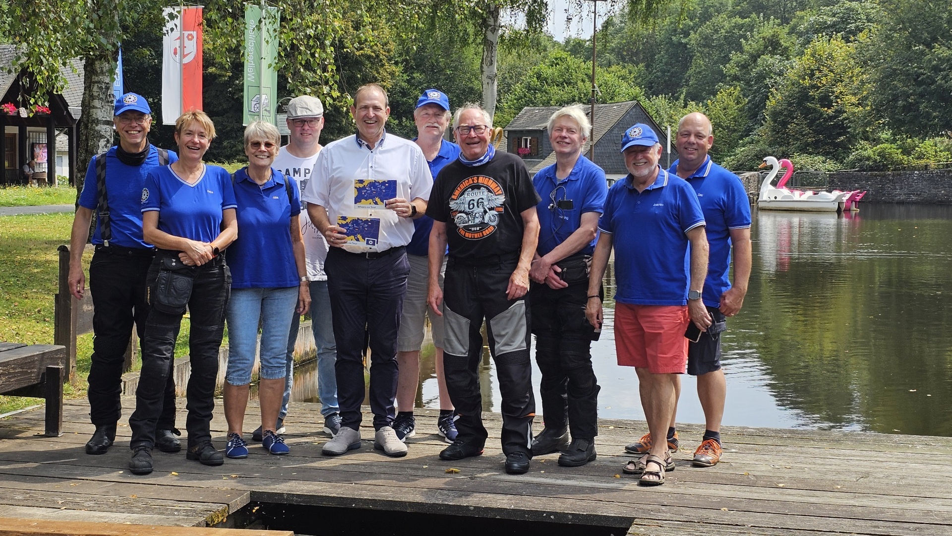 The photo shows the tour participants. Together with Mayor Frühauf, they stand next to each other on a footbridge at the Kallwiesweiher pond and look into the camera.
