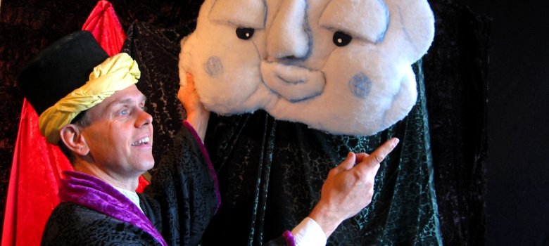 The photo shows an actor dressed in oriental clothing and holding up a plush figure in the shape of a cloud in front of him.