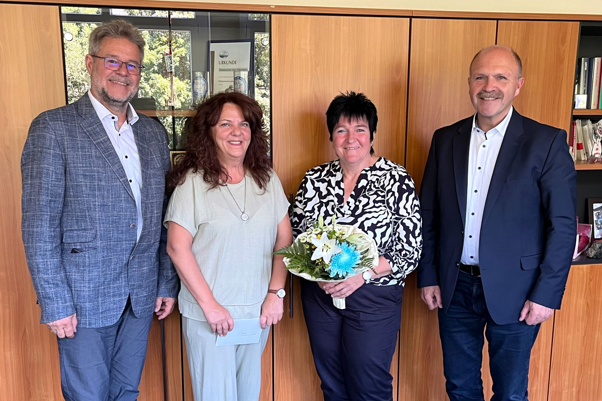 The photo shows Christine Brosch at her retirement ceremony, surrounded by colleagues, superiors and the staff council.
