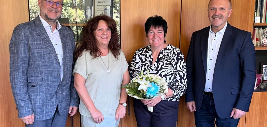 The photo shows Christine Brosch at her retirement ceremony, surrounded by colleagues, superiors and the staff council.