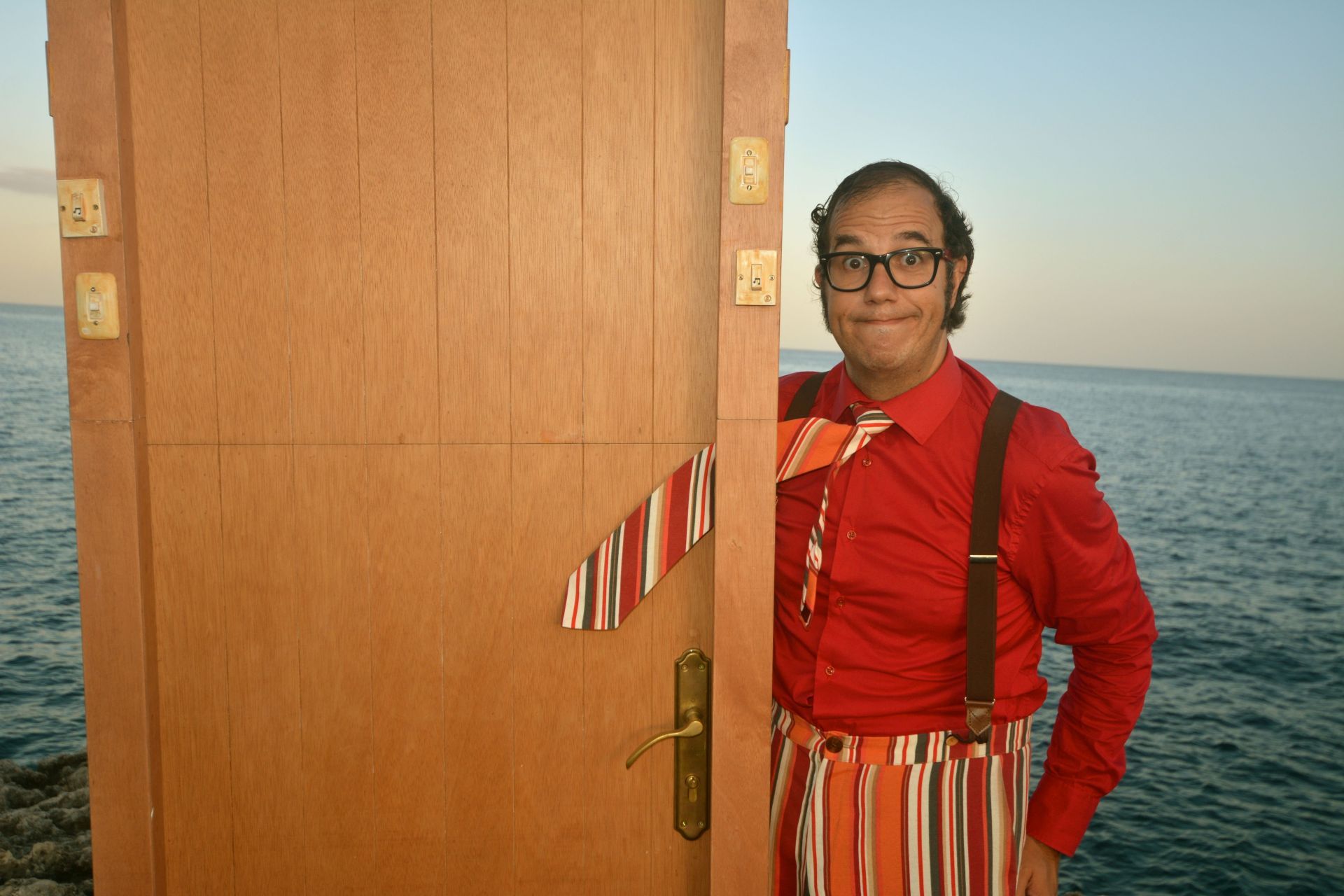 The photo shows the artist and a door with a pinched tie.