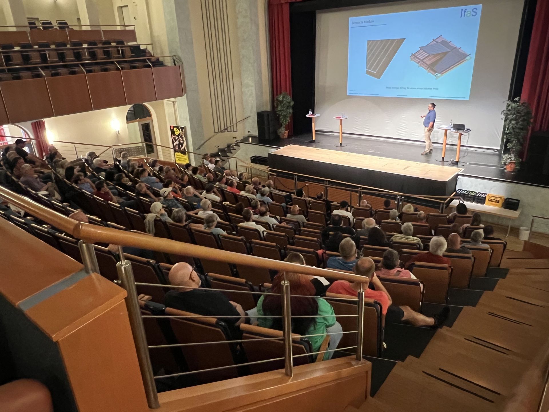The photo shows the lower section of the theater hall in the Stadttheater, which is well occupied for the information event.