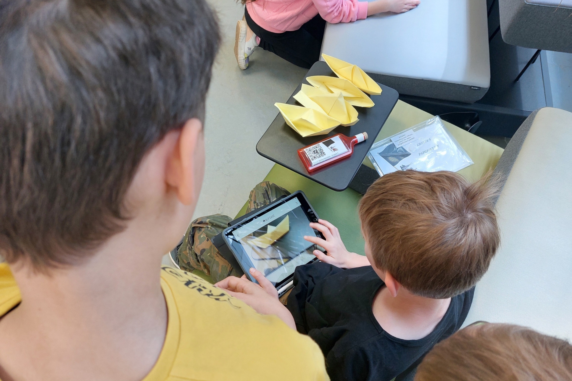 The photo shows a child editing a photo on a tablet.