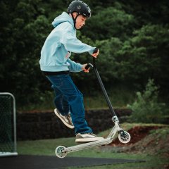The photo shows a boy on a scooter on the skating rink.
