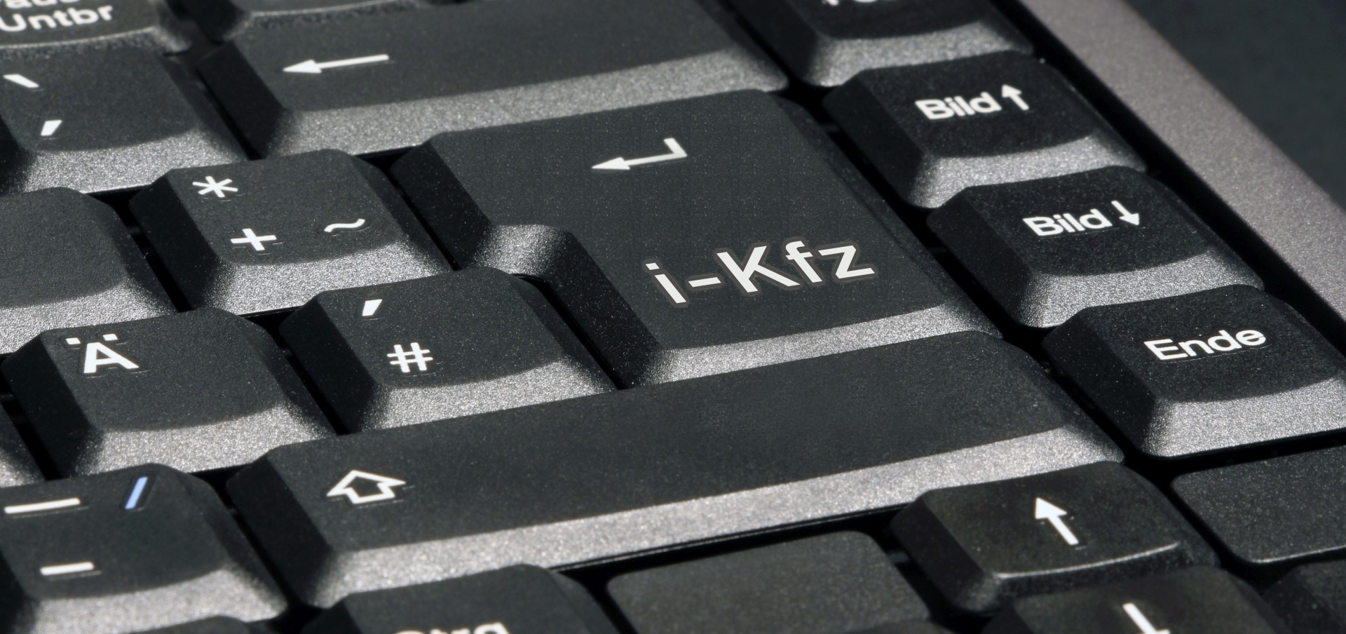 The photo shows a computer keyboard with the inscription i-Kfz as the enter key.