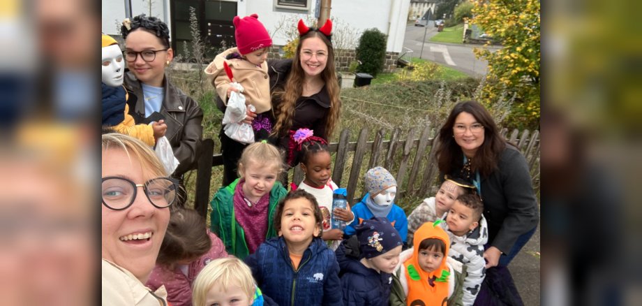 The photo shows the teachers and children during their Halloween foray.