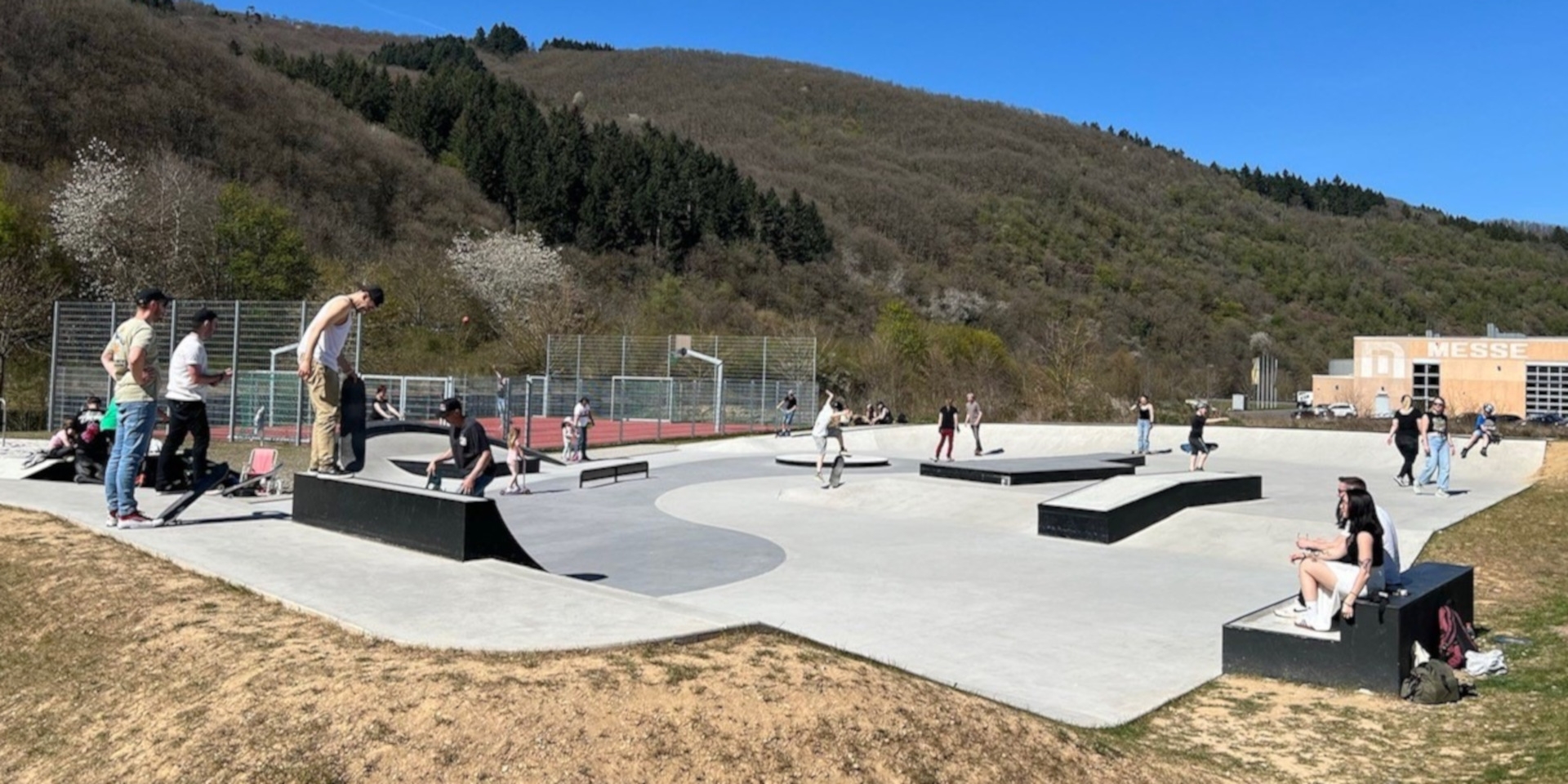 The photo shows people on the skating rink in the city park.