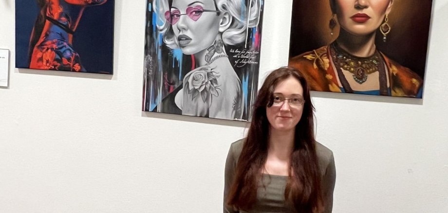 Sandra Müller in the foyer of the city administration in front of her paintings.