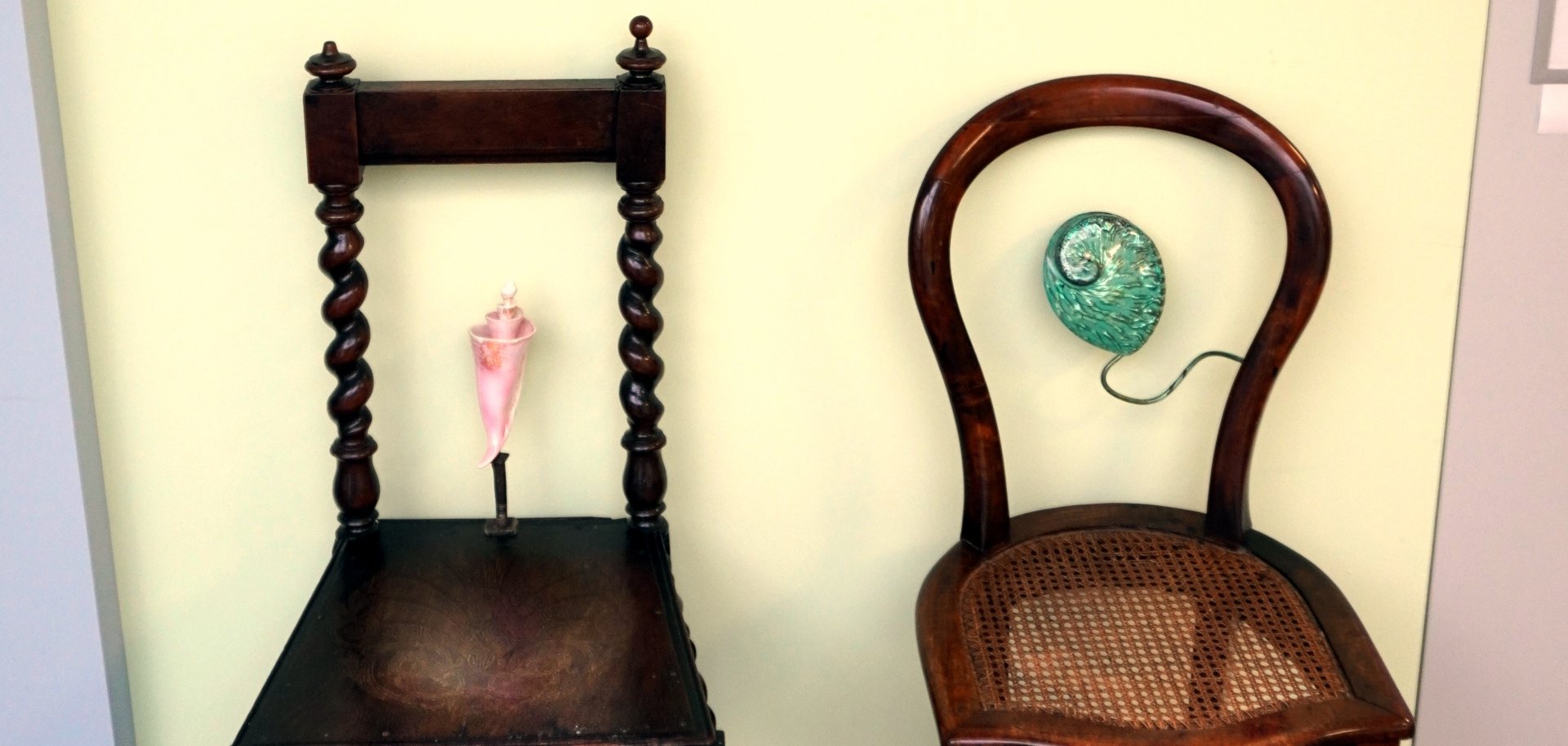The photo shows two chairs on which decorative objects are draped.