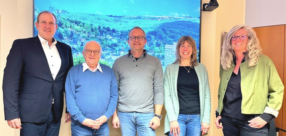 The photo shows the aforementioned people standing next to each other in the mayor's meeting room and looking into the camera.