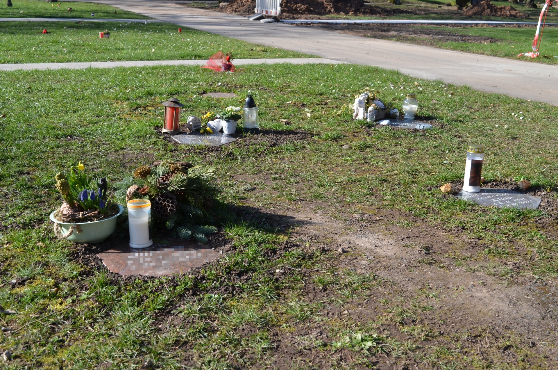The photo shows grave decorations on a burial plot.
