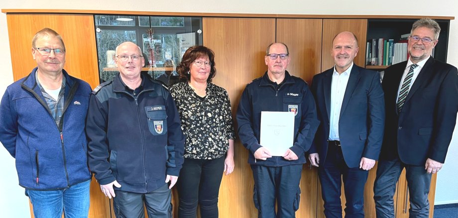 The photo shows six people, including Udo Schuff. They are standing next to each other in Mayor Marx's office and looking into the camera. Udo Schuff holds the certificate of thanks in his hands.