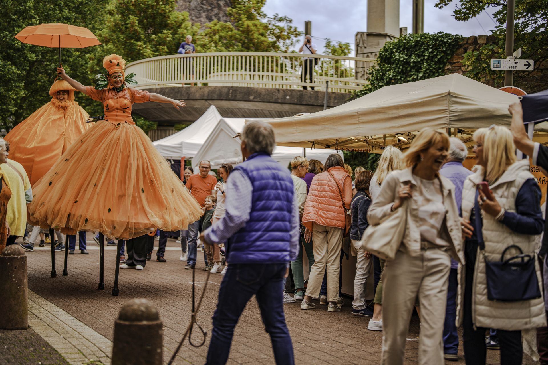 The photo shows a walk act depicting oranges on stilts.