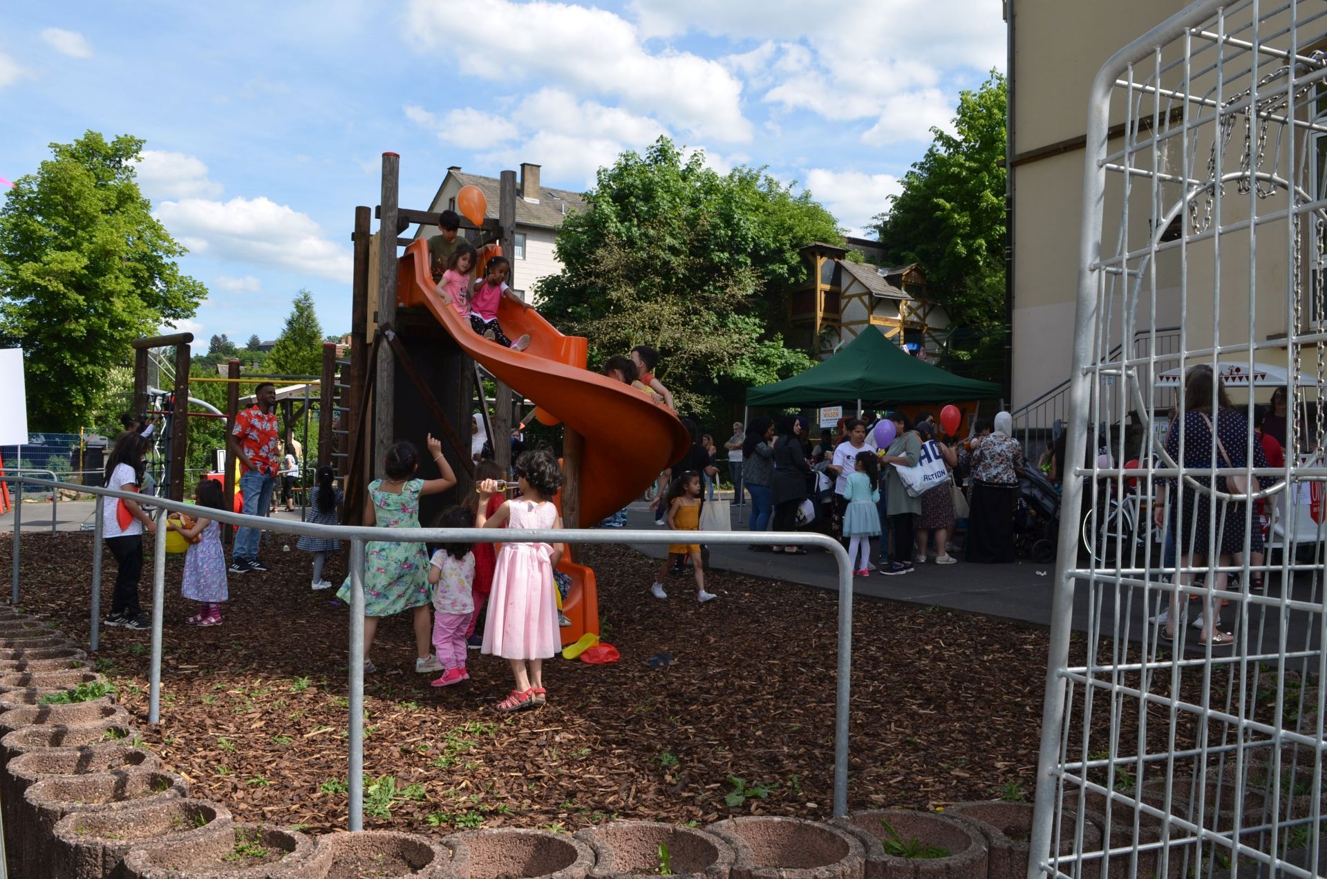 The photo shows the schoolyard of the Flurschule and many children playing on the climbing frame.