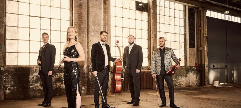 The photo shows five musicians.