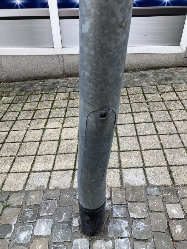 The photo shows a damaged lighting column.