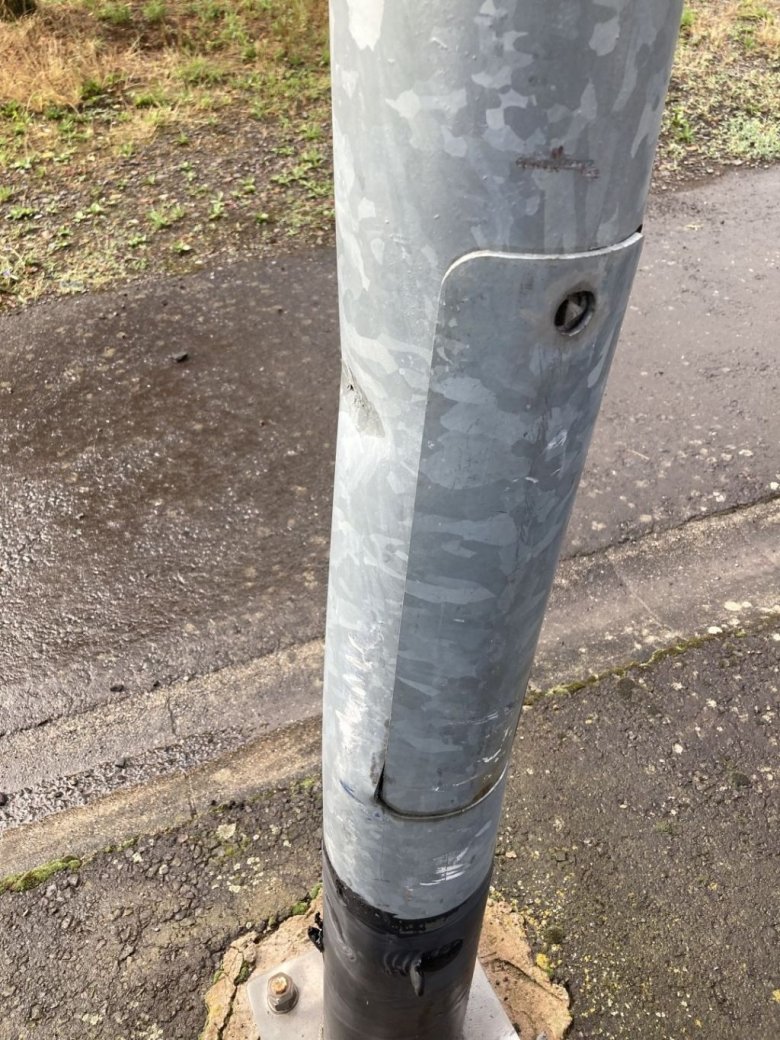 The photo shows a damaged lighting column.