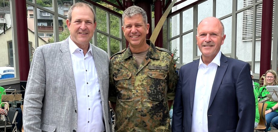 The photo shows the people mentioned. They are standing next to each other and looking into the camera.