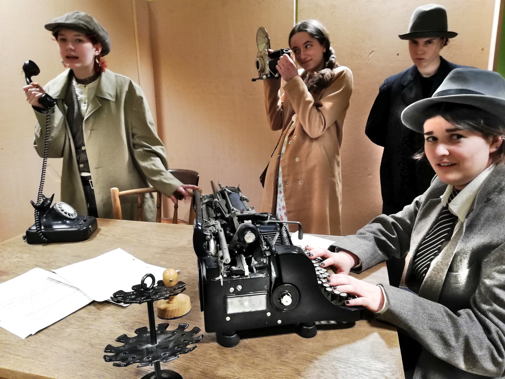 Quirky characters, intrigues and false leads make the murder investigation in the gangster milieu a captivating stage experience. The photo shows a scene with four actors and actresses dressed in 1920s-style costumes.