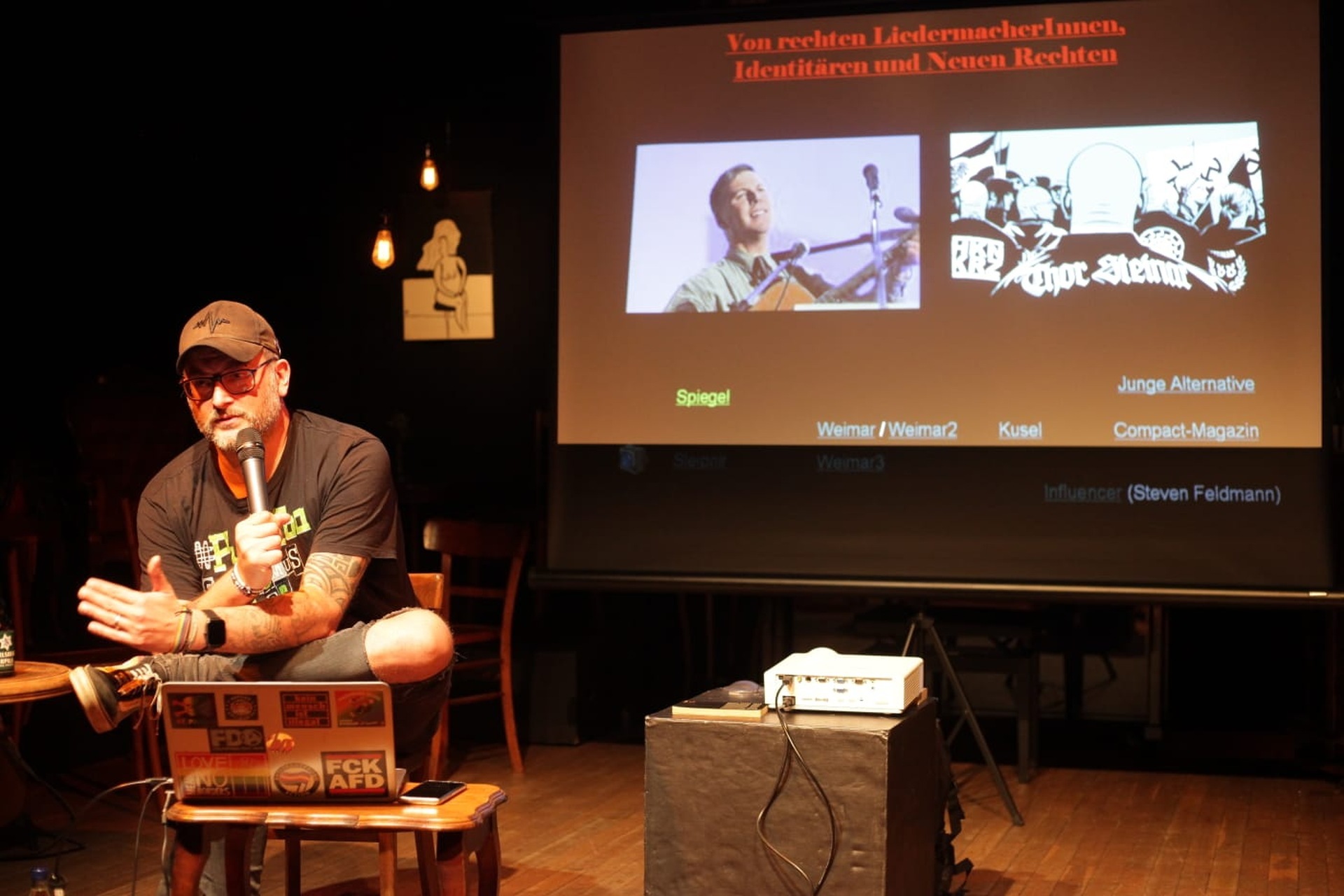 The photo shows Bastian Drumm during a presentation.