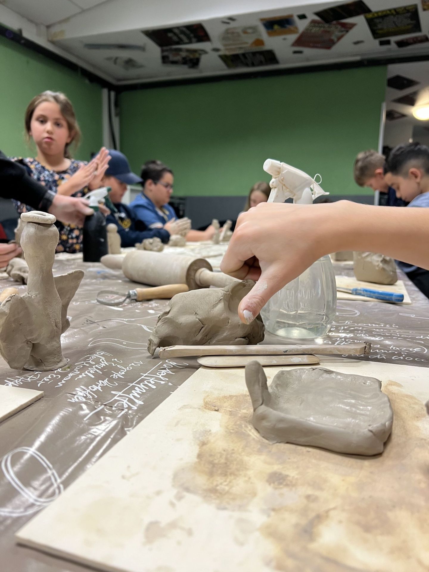 The photo shows children modeling with clay.
