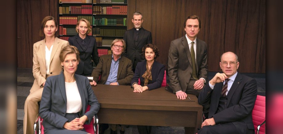 The photo shows the ensemble sitting around a table.