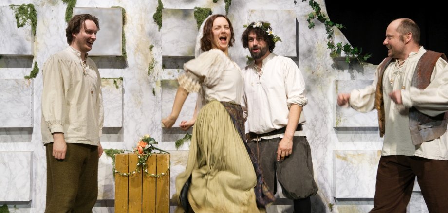 The photo shows a scene from the play with the four actors.