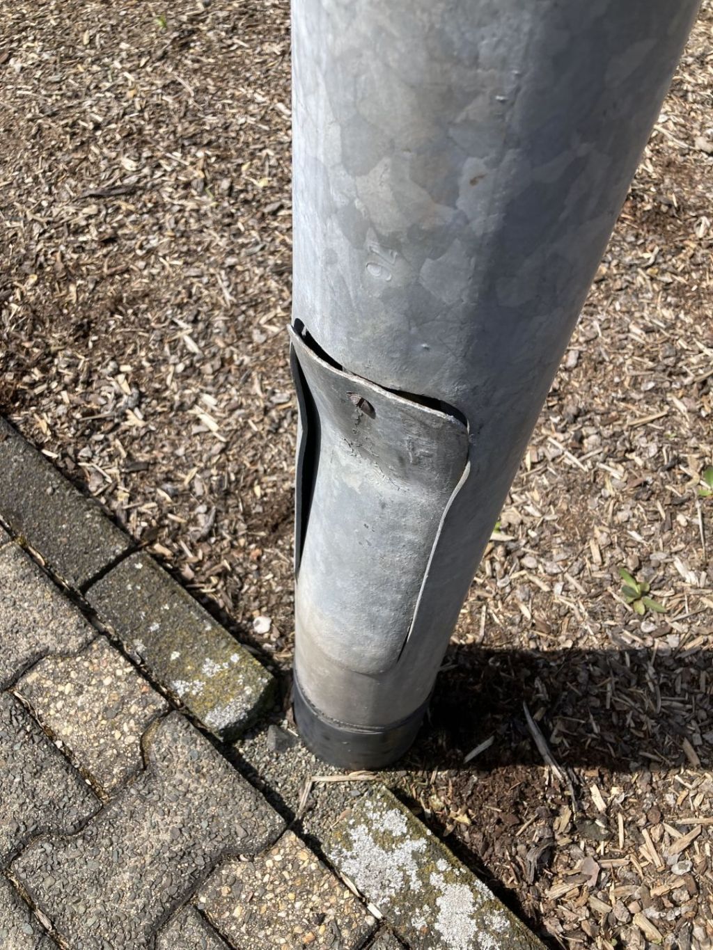 The photo shows a lamp post that was damaged in an accident.