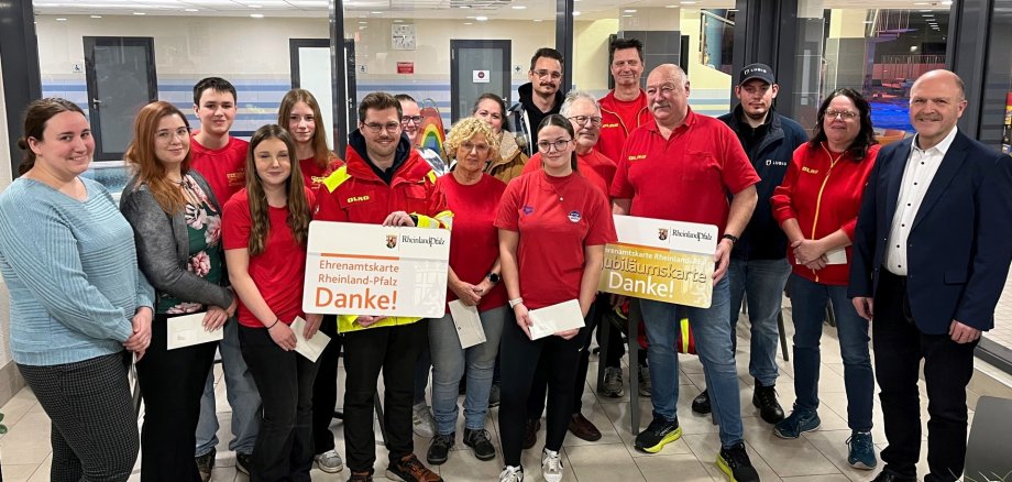 The photo shows Mayor Marx and the members of the DLRG in the foyer of the indoor pool.