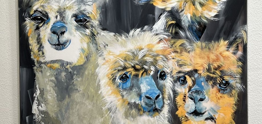 The photo shows a picture from the exhibition with three alpacas.