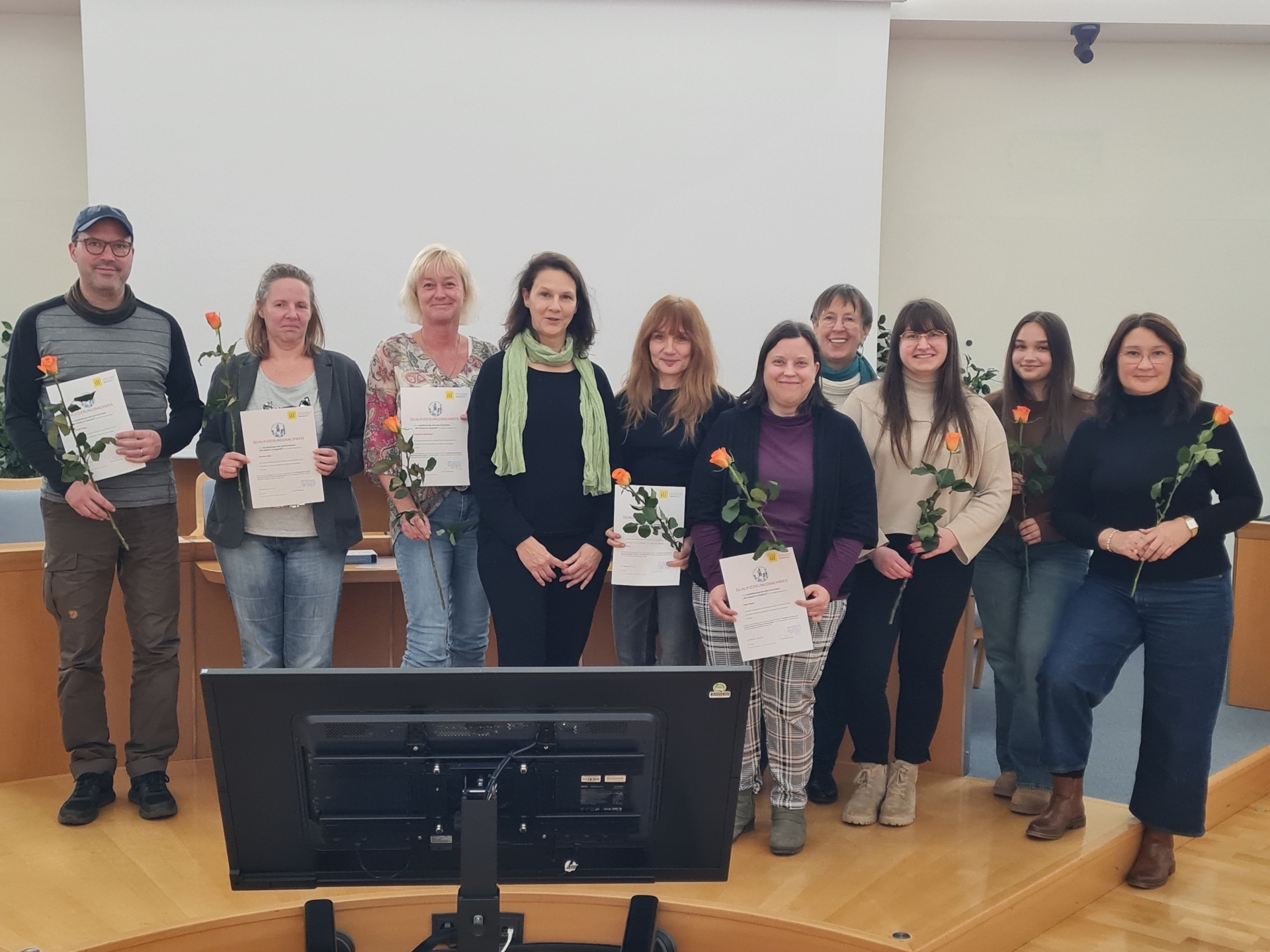 The photo shows the nine educators and the two speakers after the presentation of the certificates.